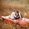 Парень с девушкой целуются сидя на красном кабриолете в п...
